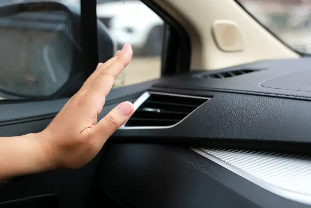 Auto AC Repair in New Oxford, PA by Premier Auto Works. Image of hand checking the cooling of the car air.