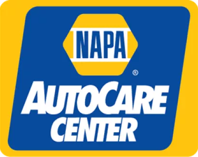 The image shows the NAPA AutoCare Center logo. It has a hexagonal shape with "NAPA" written in blue letters inside a yellow bar. Below the hexagon, "AutoCare Center" is written in bold, white letters against a blue background. The entire logo is framed in yellow.