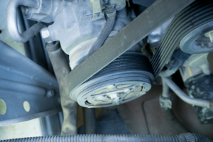 Auto air conditioning and heater repair in New Oxford, PA. Image of air conditioner pully and belt on car in shop for services.
